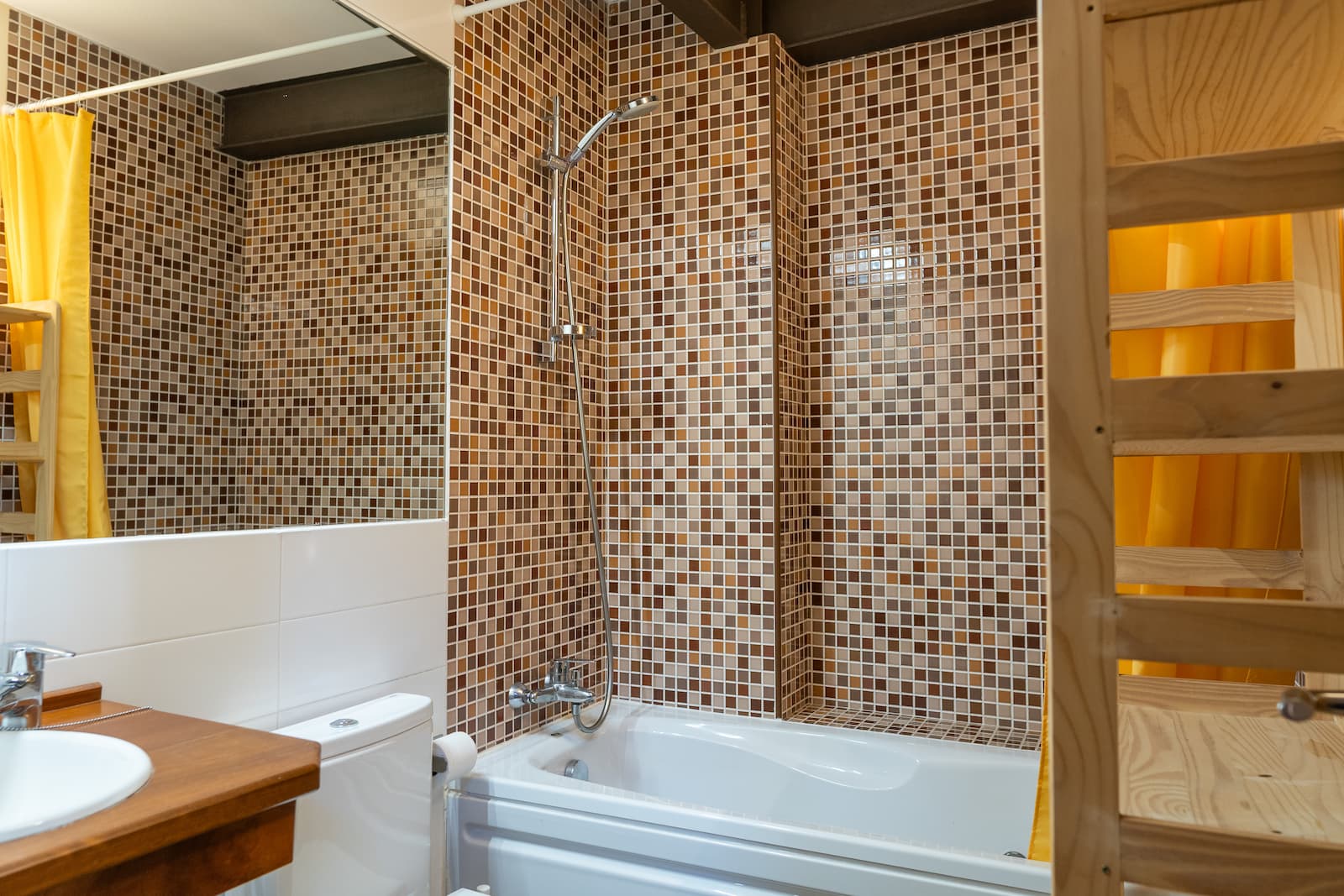 Baño completo con bañera y revestimiento de mosaico de la casa rural en Talaveruela de la Vera, Cáceres