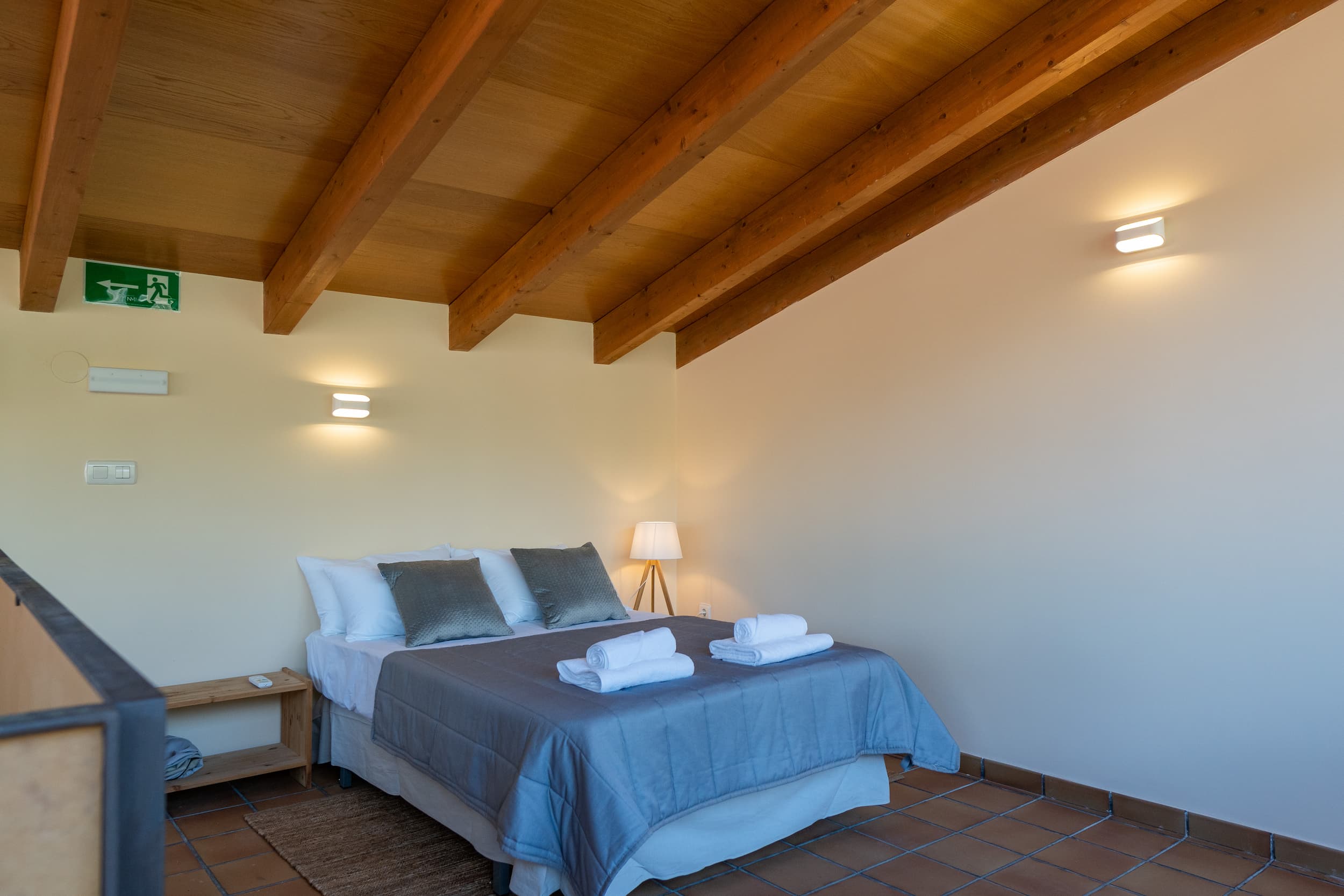 Dormitorio buhardilla con cama y techo de madera en la casa rural en La Vera, Cáceres