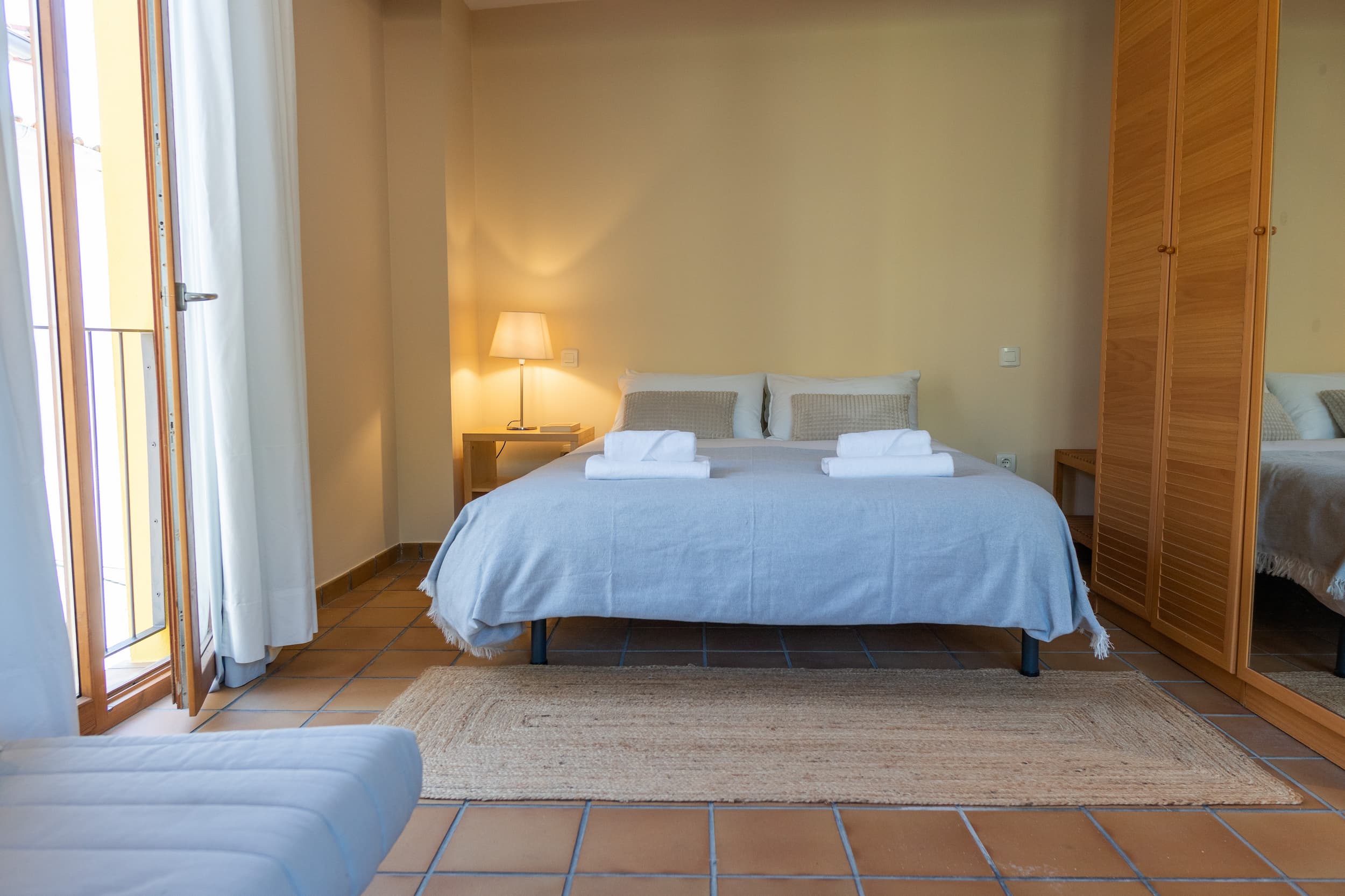 Dormitorio principal con suelo tradicional de barro de la casa rural en Talaveruela de la Vera