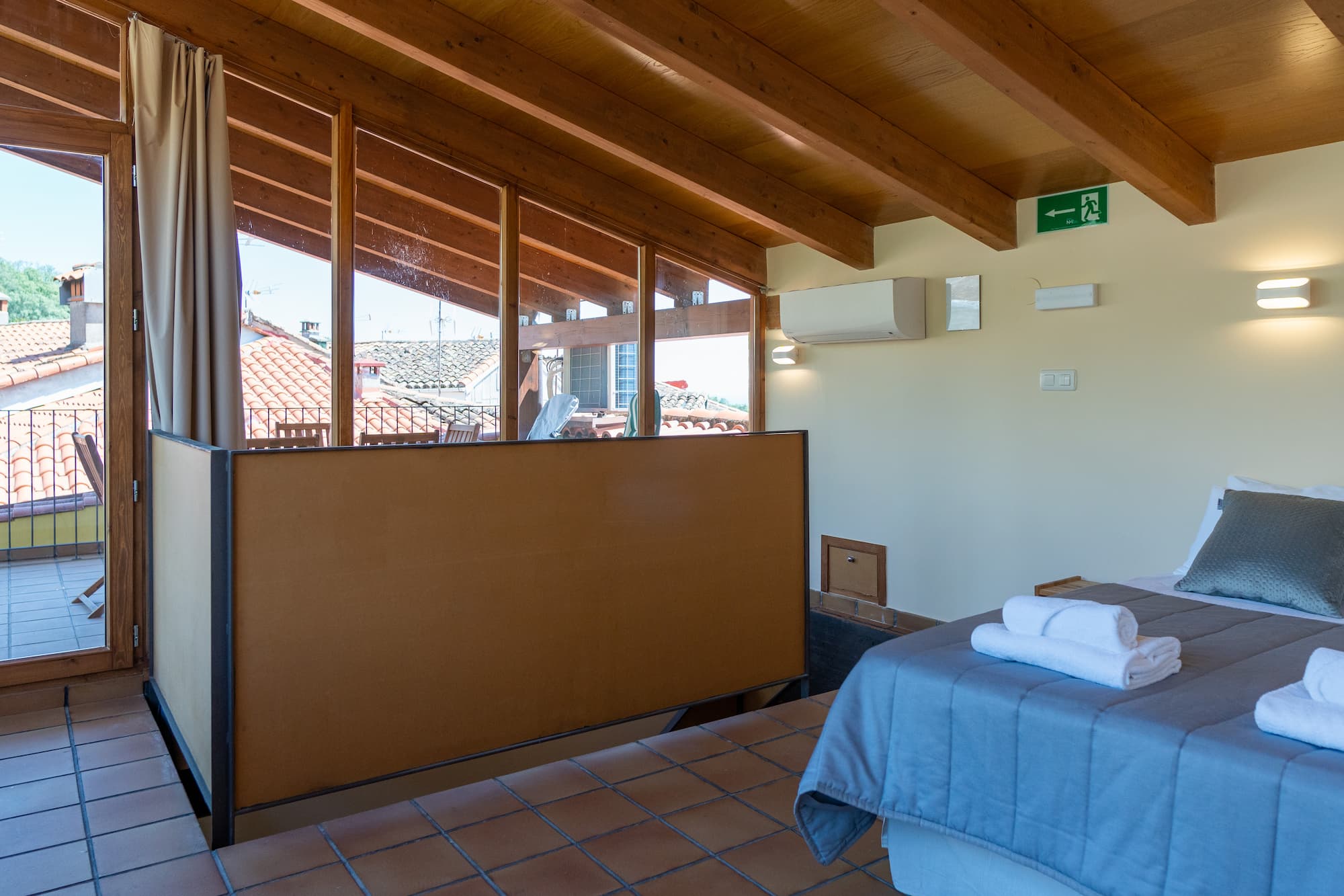 Buhardilla con camas y grandes ventanales con vistas en la casa rural en Talaveruela de la Vera