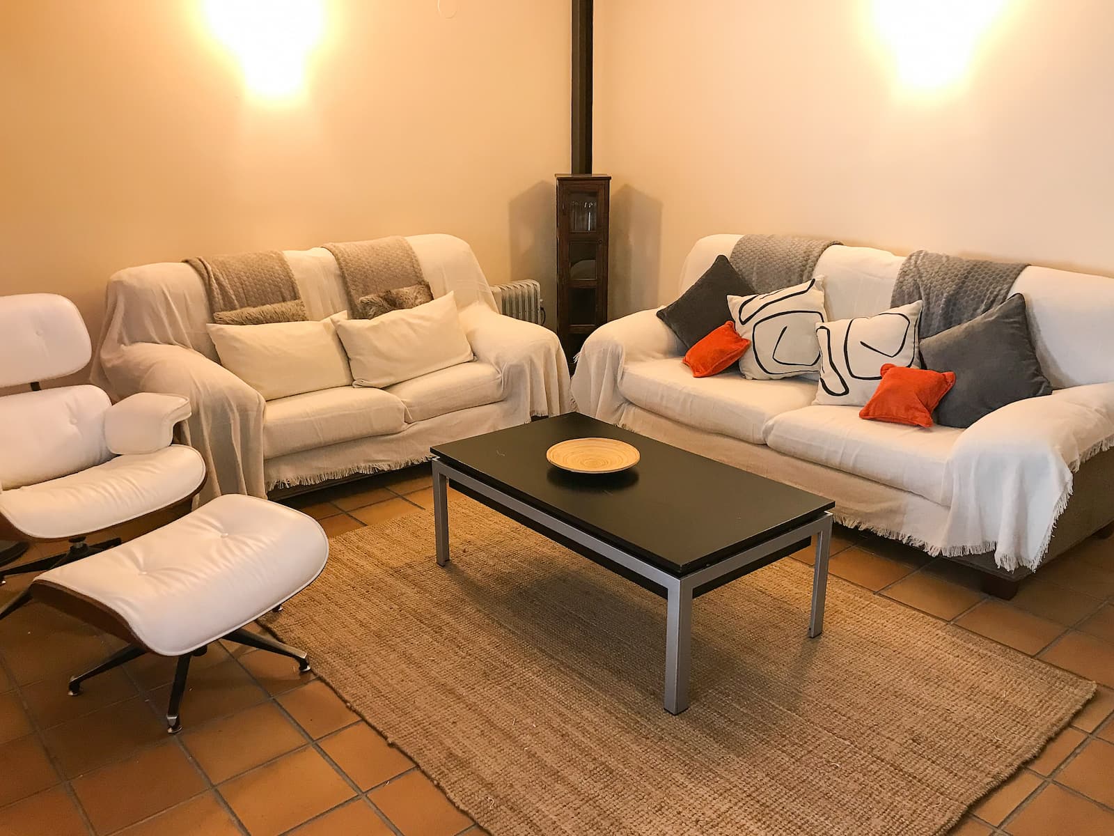 Salón con estufa de leña y sofás en la casa rural en Talaveruela de la Vera, Cáceres