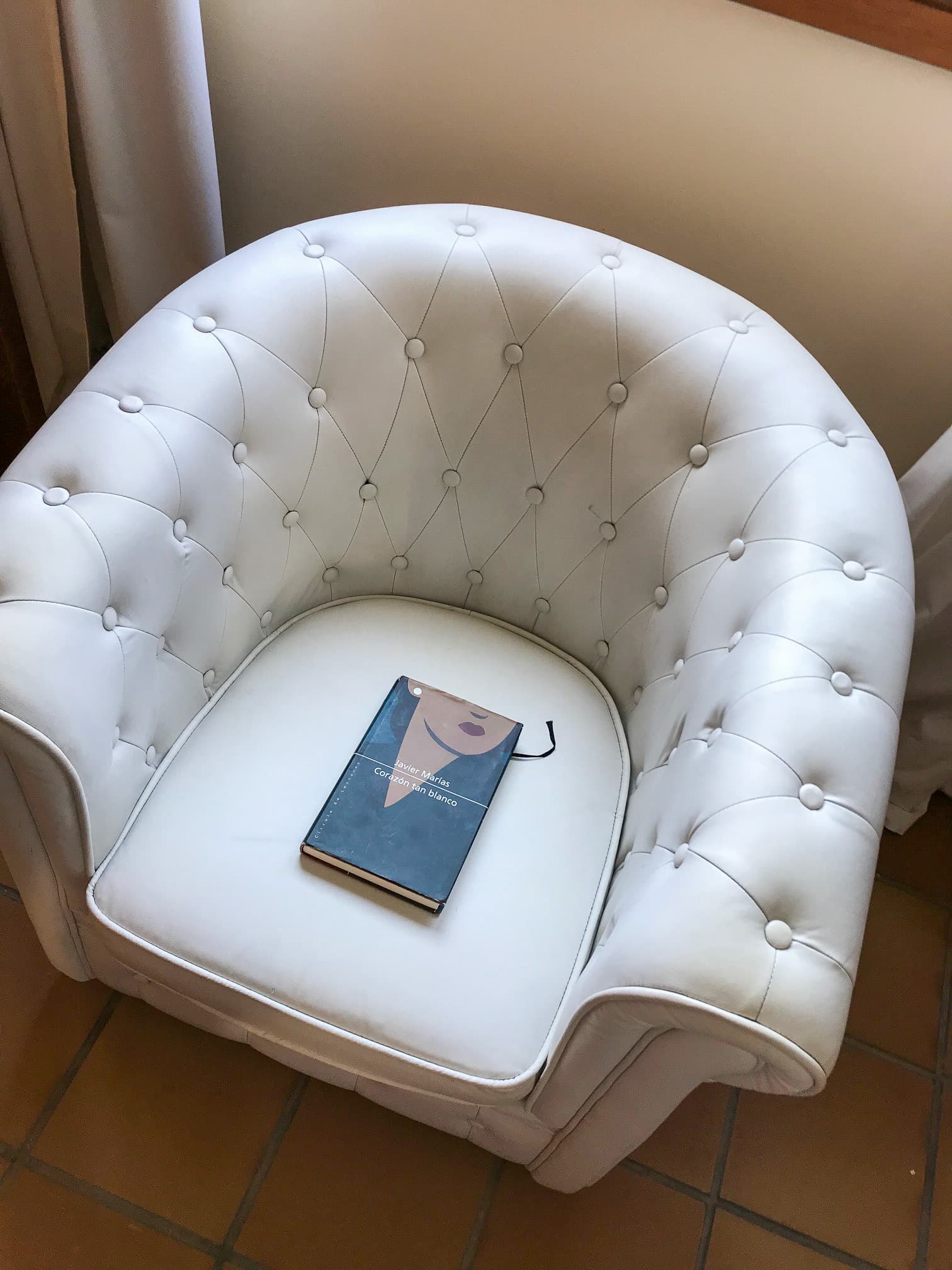 Rincón de lectura con sillón en el dormitorio principal de la casa rural en Talaveruela de la Vera
