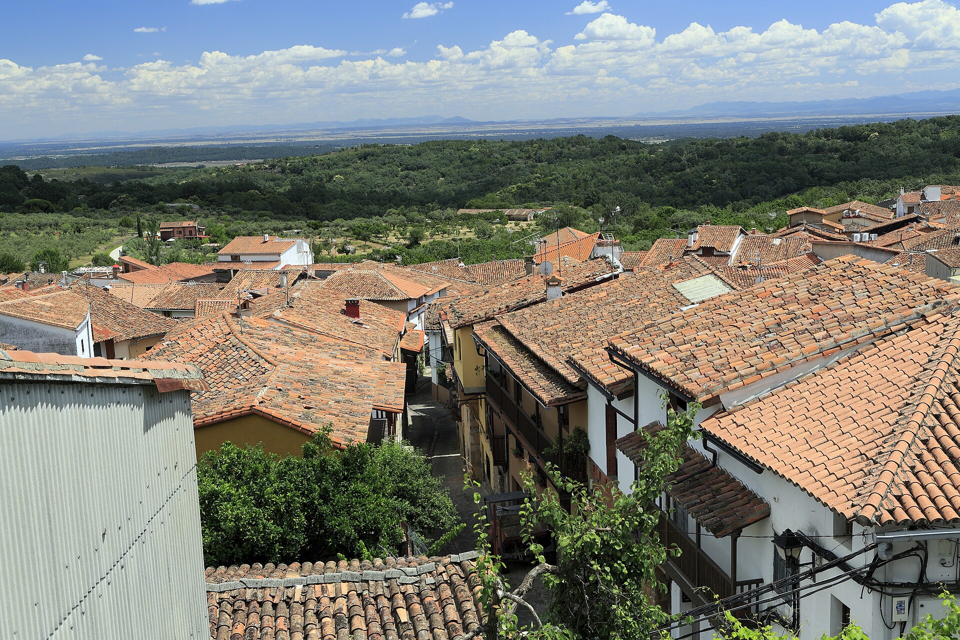 Tejados tradicionales de un pueblo de La Vera y el valle del Tiétar al fondo